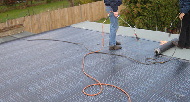 Straight-forward felt roof being torched.